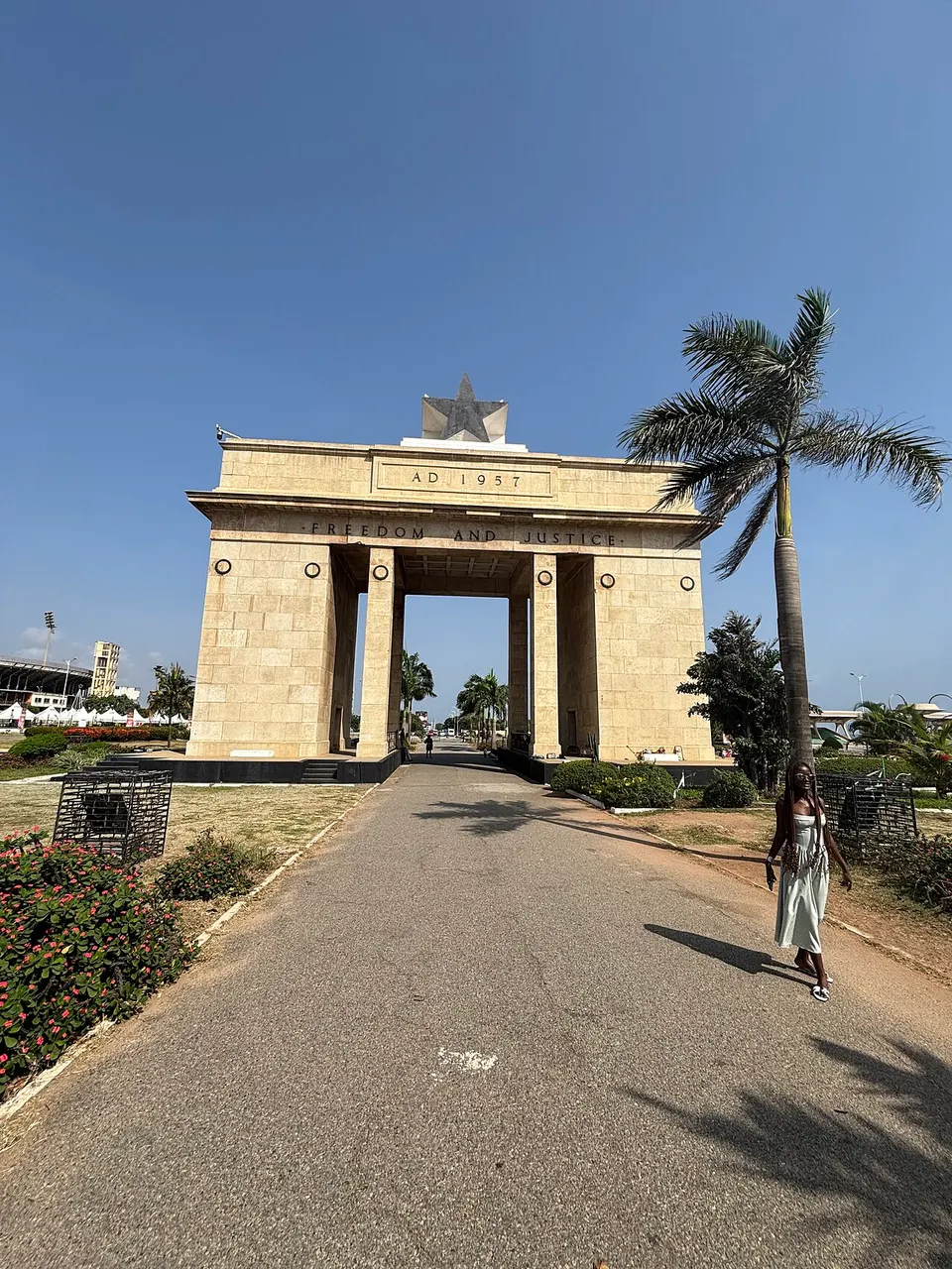 Arco da Independência na Praça da Estrela Negra, em Acra, com a estrela negra no alto, sob céu azul.