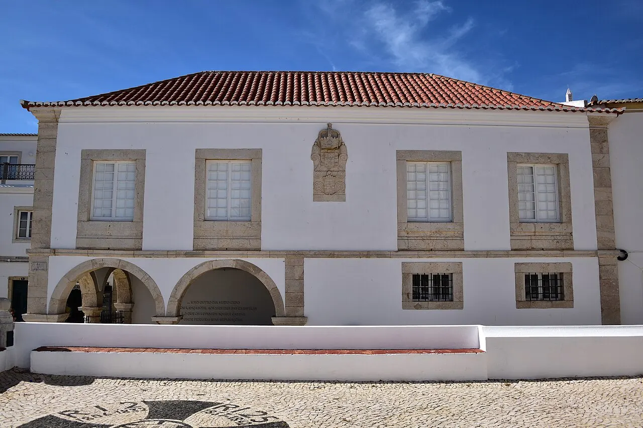 O edifício branco do Mercado de Escravos, na praça do Infante, em Lagos, com dois arcos no térreo e telhado de telha.