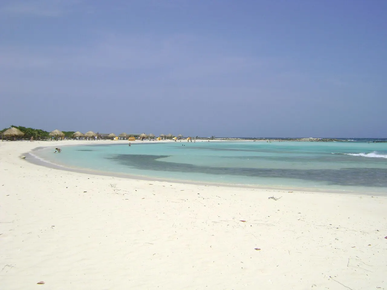 La curva de arena blanca de Baby Beach alrededor de una laguna poco profunda y turquesa, protegida del mar abierto.