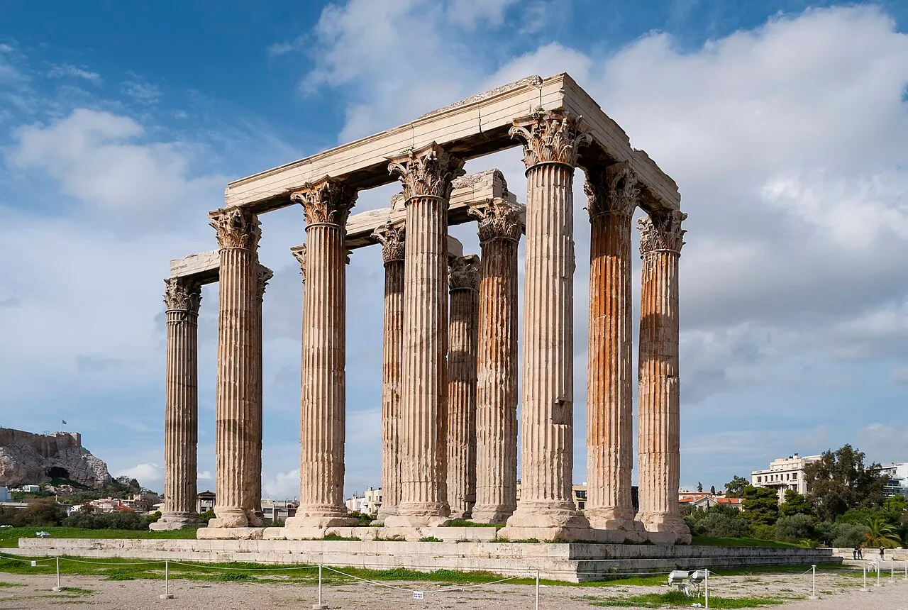 Colunas coríntias que restam do Templo de Zeus Olímpico, em Atenas, sob céu azul.