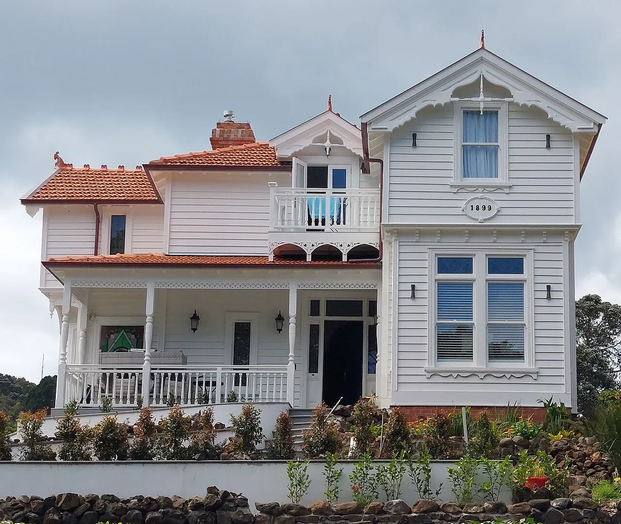 Casa vitoriana de madeira branca em Devonport, com varanda e telhado de duas águas.