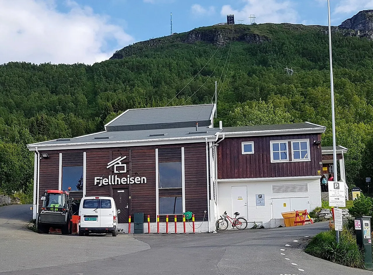 Estação inferior do teleférico Fjellheisen, em Tromsø, um prédio de madeira escura ao pé da montanha.