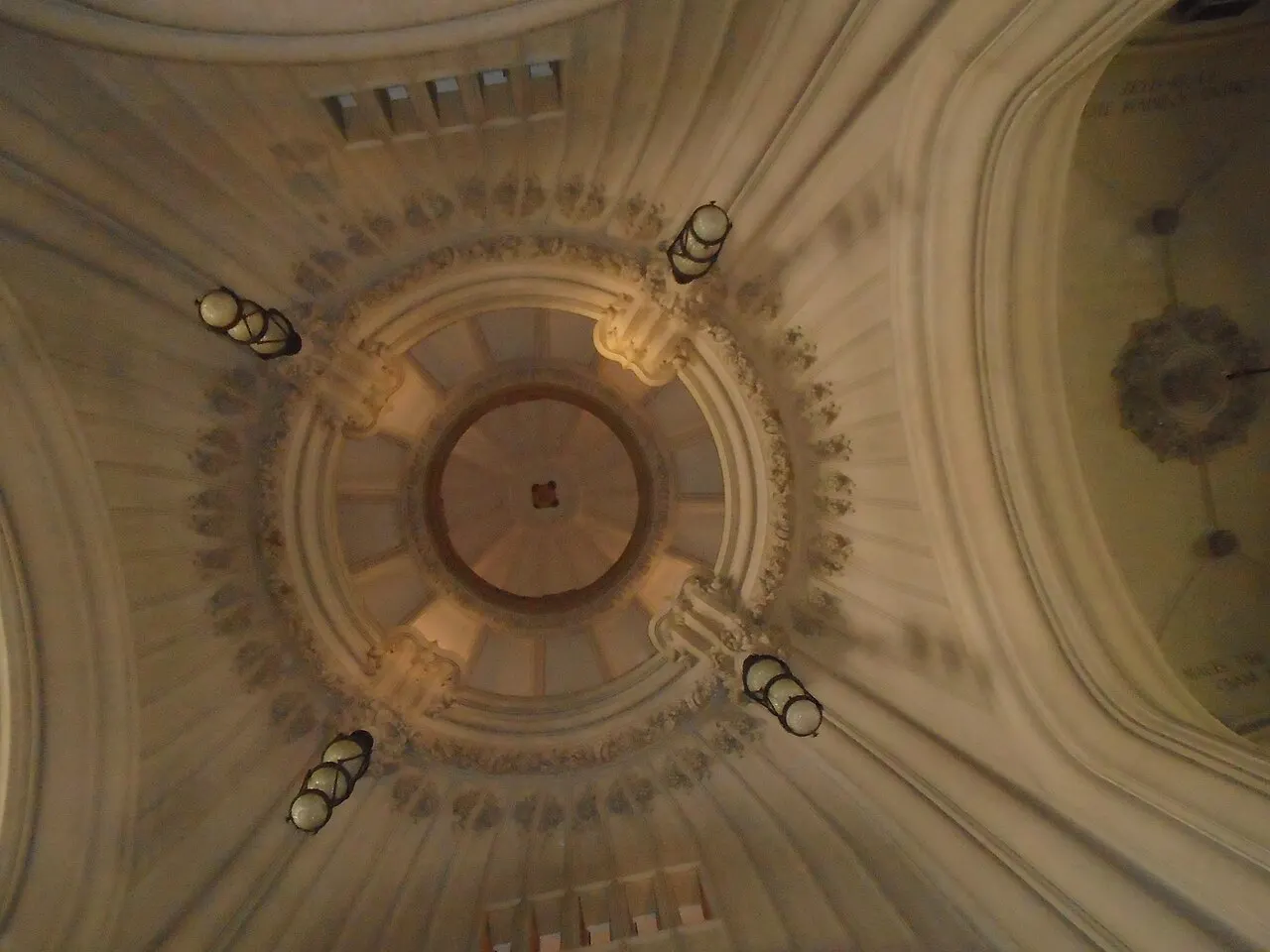 Interior da cúpula do Palacio Barolo, visto de baixo, com anéis de relevo e luminárias.