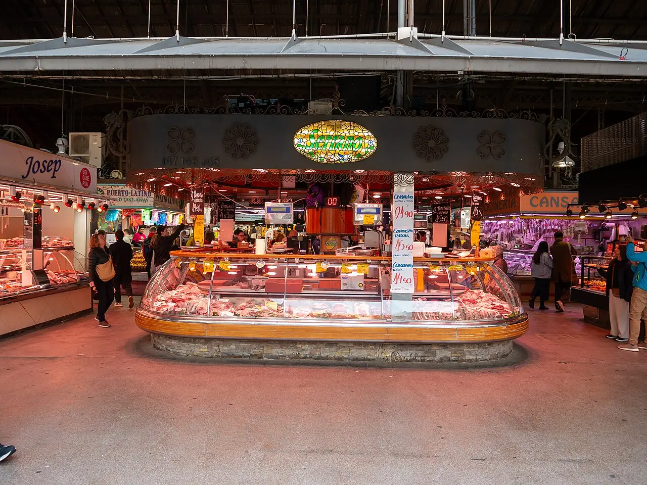 Corredor de La Boqueria, com uma banca oval de carne no centro e outras bancas dos dois lados.