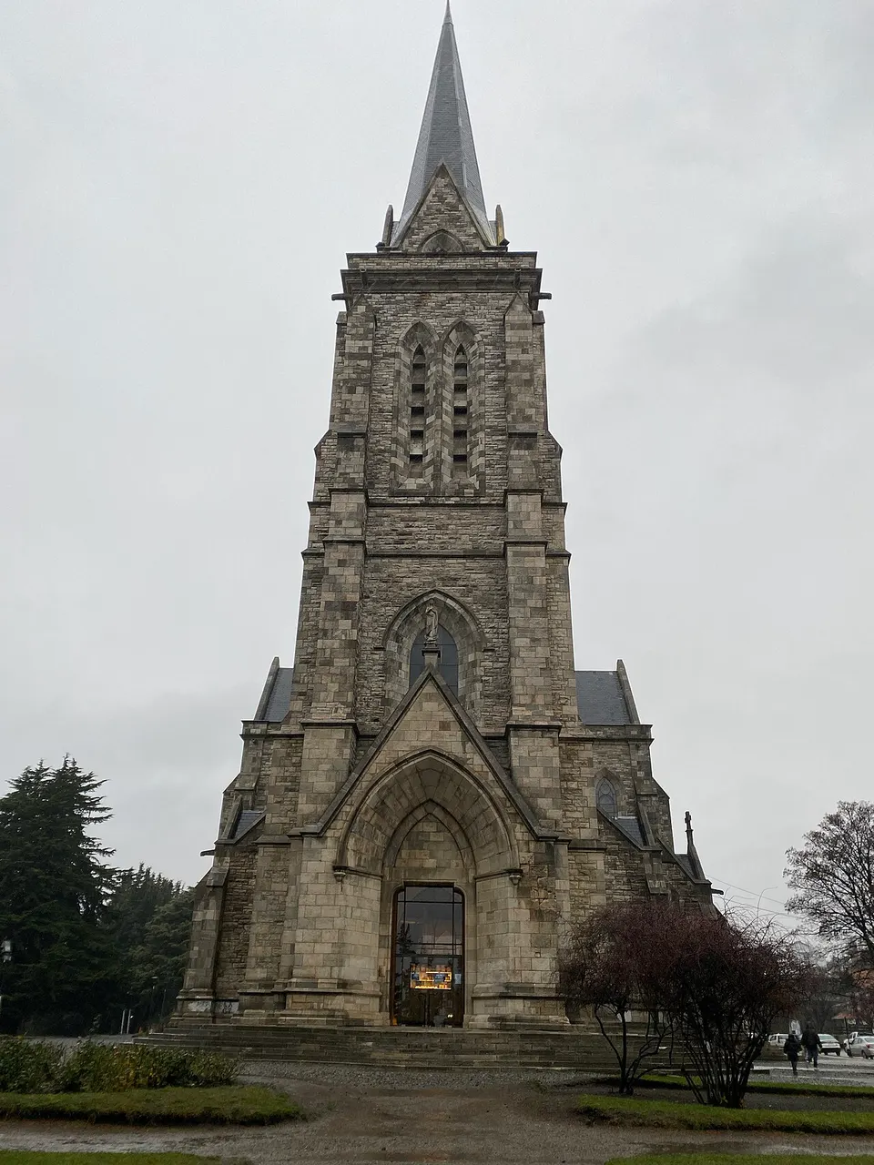 Catedral de Nuestra Señora del Nahuel Huapi, em Bariloche, de pedra, com a torre de agulha sob céu nublado.