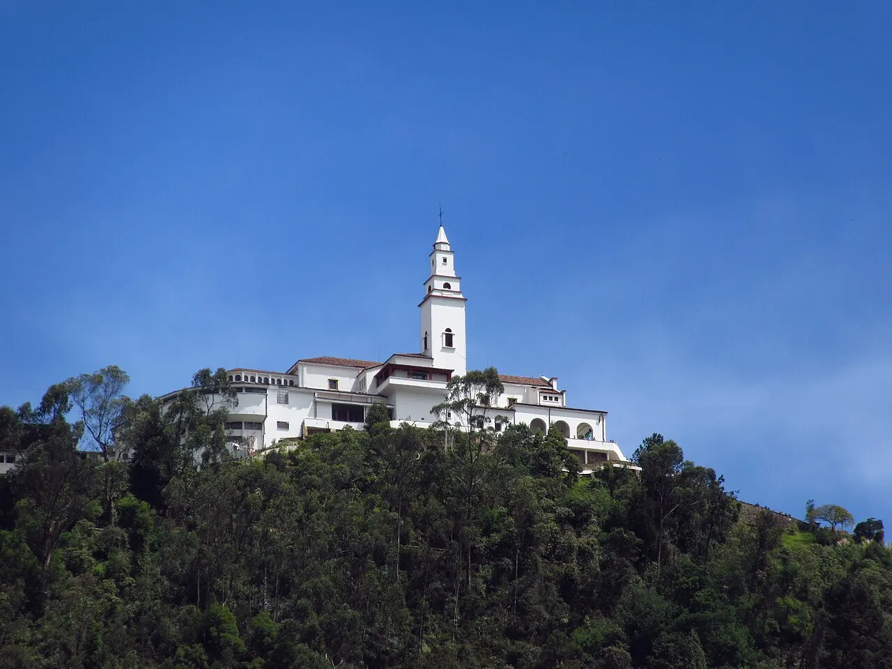 O santuário branco no alto do cerro de Monserrate, contra o céu azul.