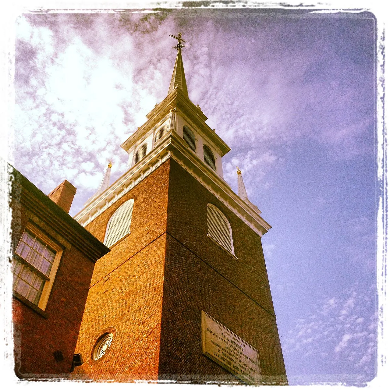 Campanário branco da Old North Church, em Boston, visto de baixo contra o céu claro.
