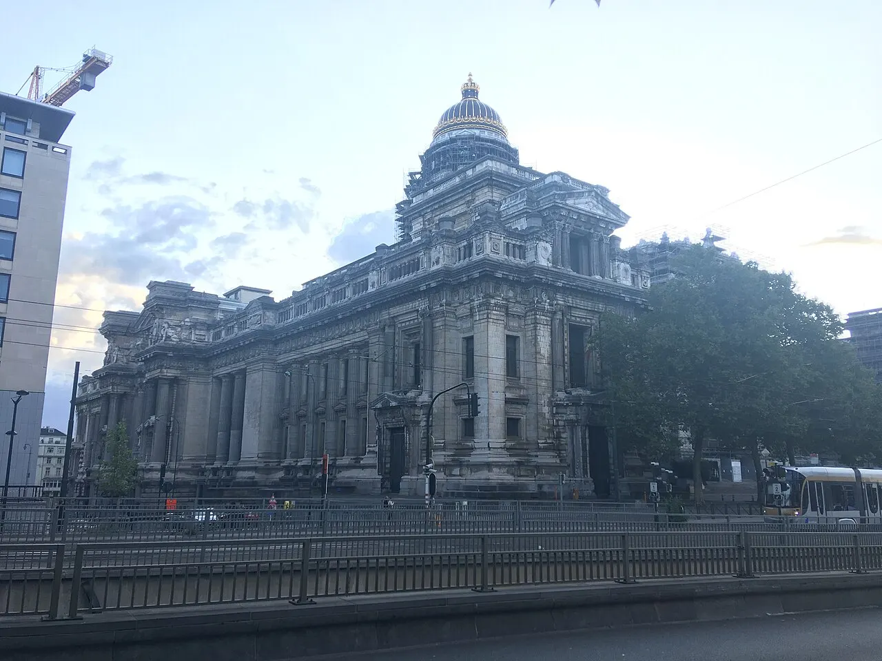 Palácio de Justiça de Bruxelas visto de esquina, com a cúpula dourada cercada de andaimes na base.
