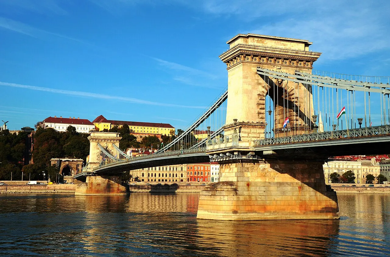 A Ponte das Correntes cruza o Danúbio, com o pilar de pedra, as correntes e o palácio no alto da colina de Buda.
