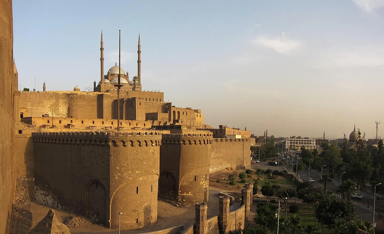 Cidadela de Saladino, no Cairo, com as muralhas de pedra e, atrás, as cúpulas e minaretes da mesquita de Muhammad Ali.