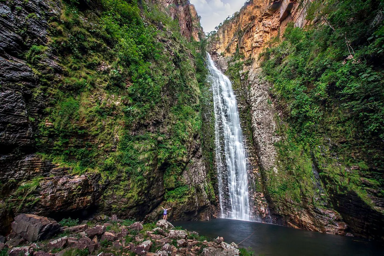 A Cachoeira do Segredo, alta e fina, caindo entre paredões cobertos de vegetação até o poço no fundo do cânion.