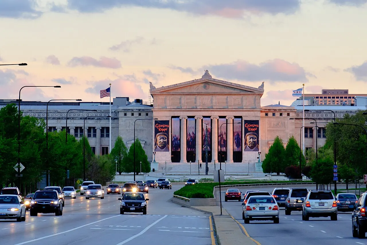Le Field Museum, à Chicago, avec son portique à colonnes et ses bannières, vu de l'avenue au crépuscule.