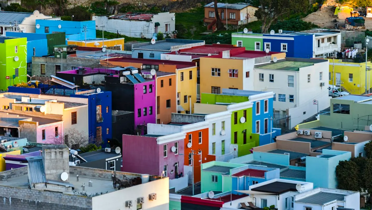 Casas do Bo-Kaap, vistas de cima, juntam fachadas verdes, azuis, roxas, laranja, amarelas e rosa sob telhados brancos.