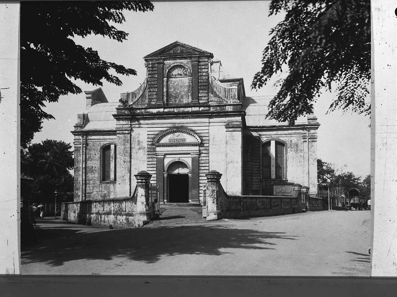 Façade d'église coloniale hollandaise, aux lignes sobres et fronton triangulaire, sur une photo ancienne en noir et blanc.