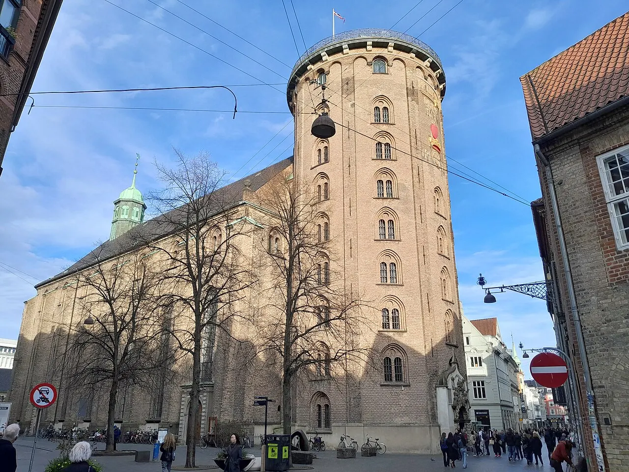 Rundetårn, a torre redonda de Copenhague, com a fachada clara e o prédio anexo, vista da rua.