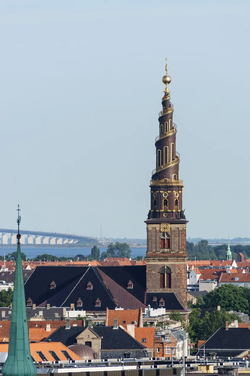 Torre em espiral da Vor Frelsers Kirke, em Copenhague, com a escada externa dourada, vista de longe.