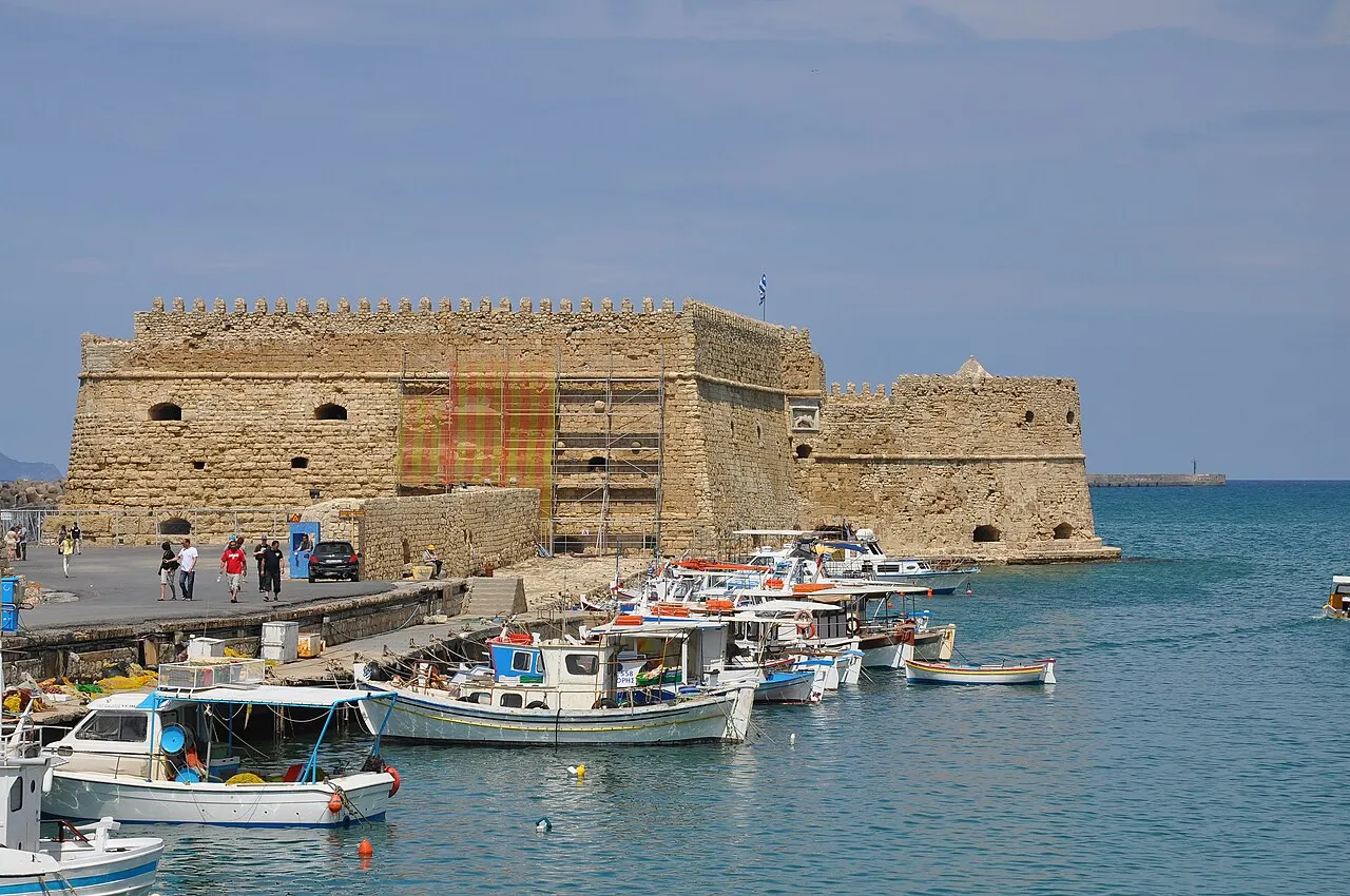 A fortaleza veneziana de Koules na ponta do porto de Heraklion, com barcos de pesca atracados no cais diante dela.