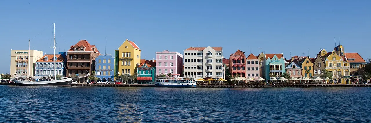 A fileira de fachadas coloridas da Handelskade, em Willemstad, à beira da baía de Santa Ana, vista da outra margem.