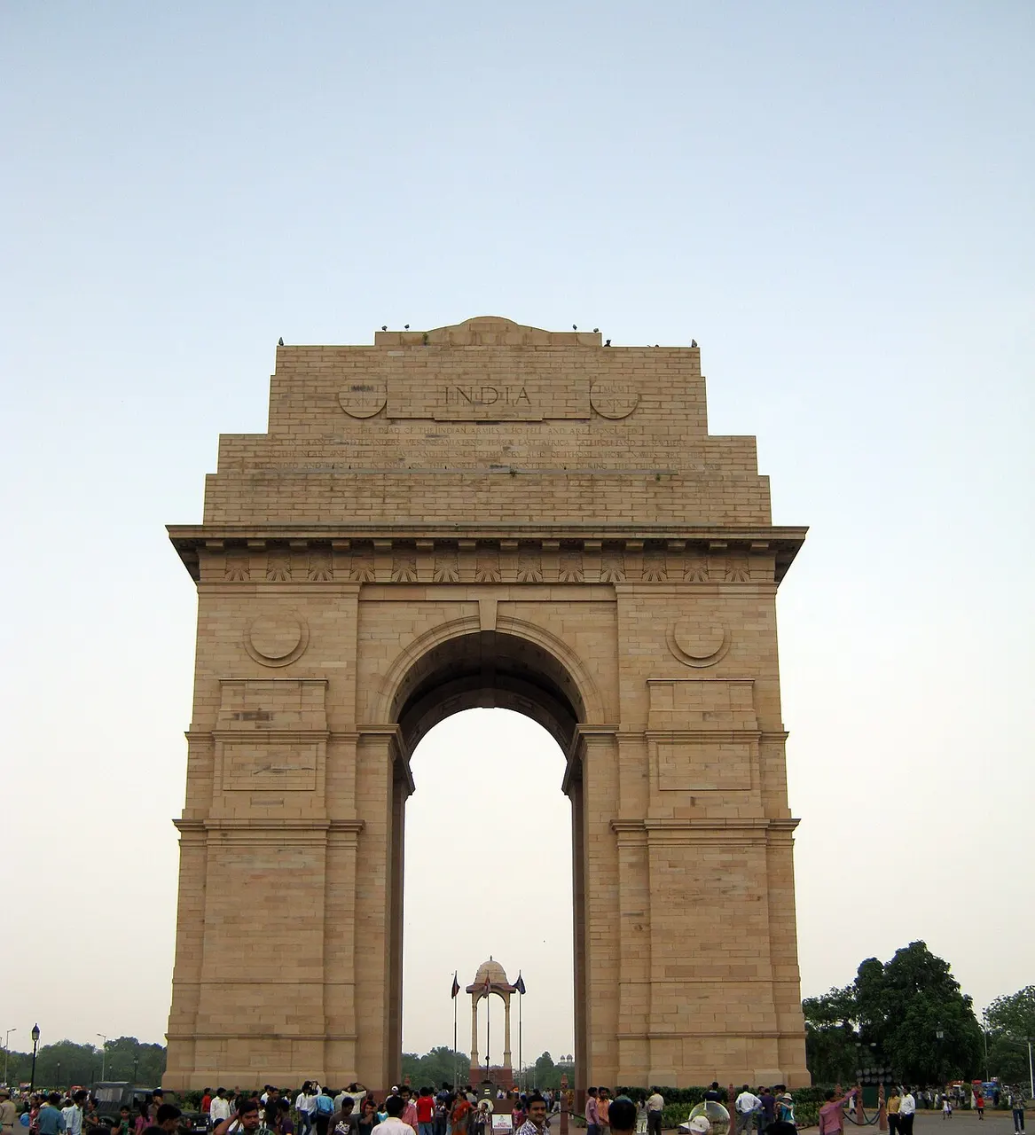 Arco monumental de arenito com um único vão alto, contra o céu claro.