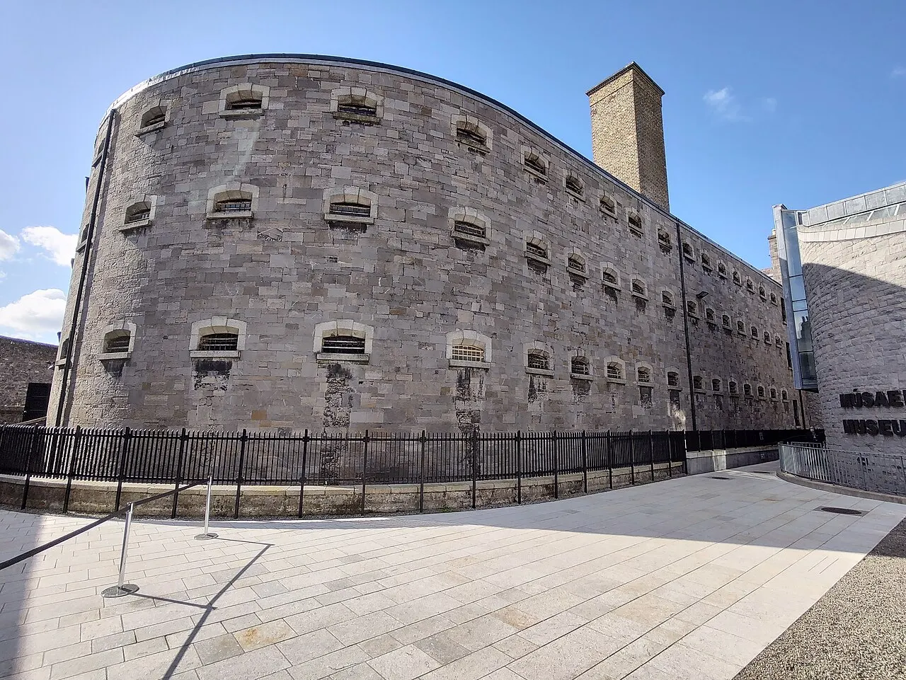 Ala de pedra da antiga prisão de Kilmainham, em Dublin, com janelas pequenas e uma chaminé alta.