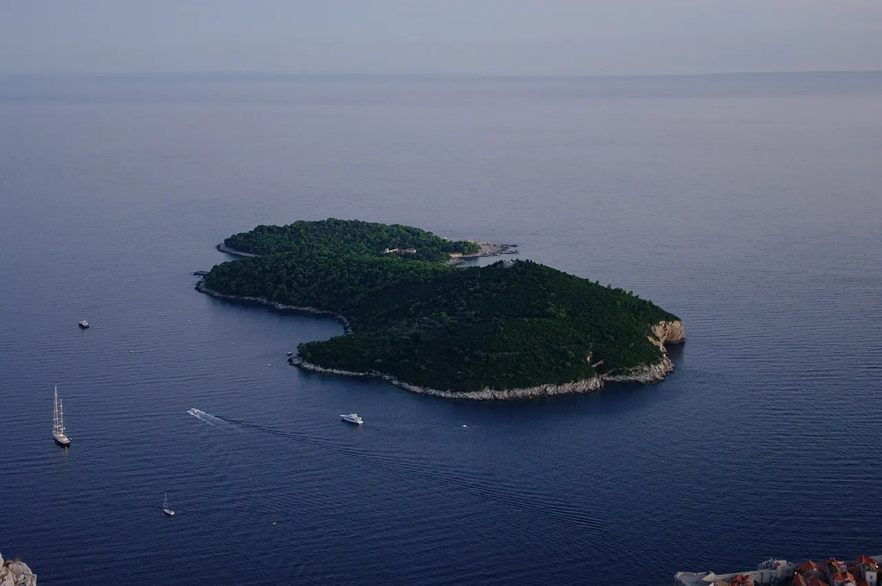 Ilha de Lokrum, coberta de mata, cercada pelo mar azul, vista do alto.