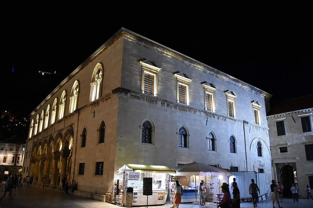 Palácio do Reitor, em Dubrovnik, com a loggia de arcos no térreo, iluminado à noite.