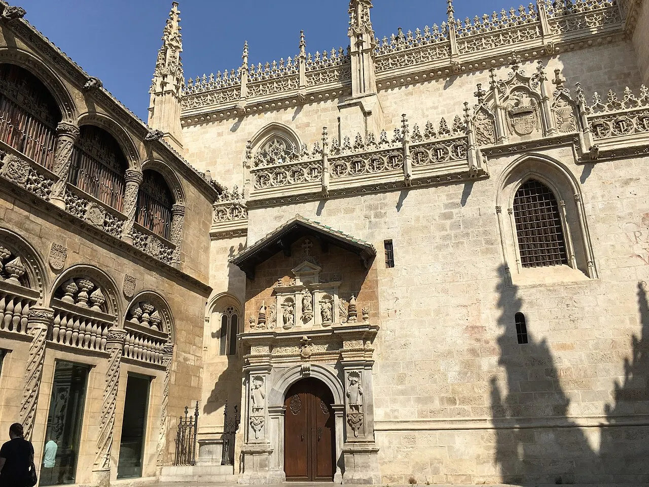 A fachada da Capilla Real de Granada, de pedra clara em estilo gótico tardio, com pináculos, rendilhado e a portada esculpida.