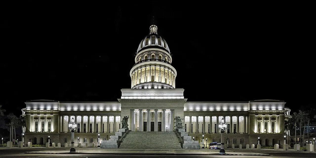 El Capitolio, em Havana, iluminado à noite, com a cúpula ao centro e as alas laterais.
