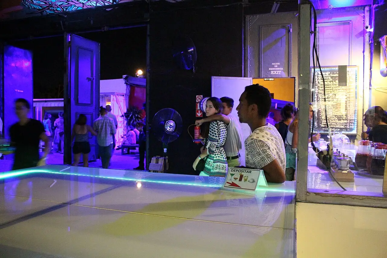 Salas com obras iluminadas e visitantes, no interior da Fábrica de Arte Cubano.