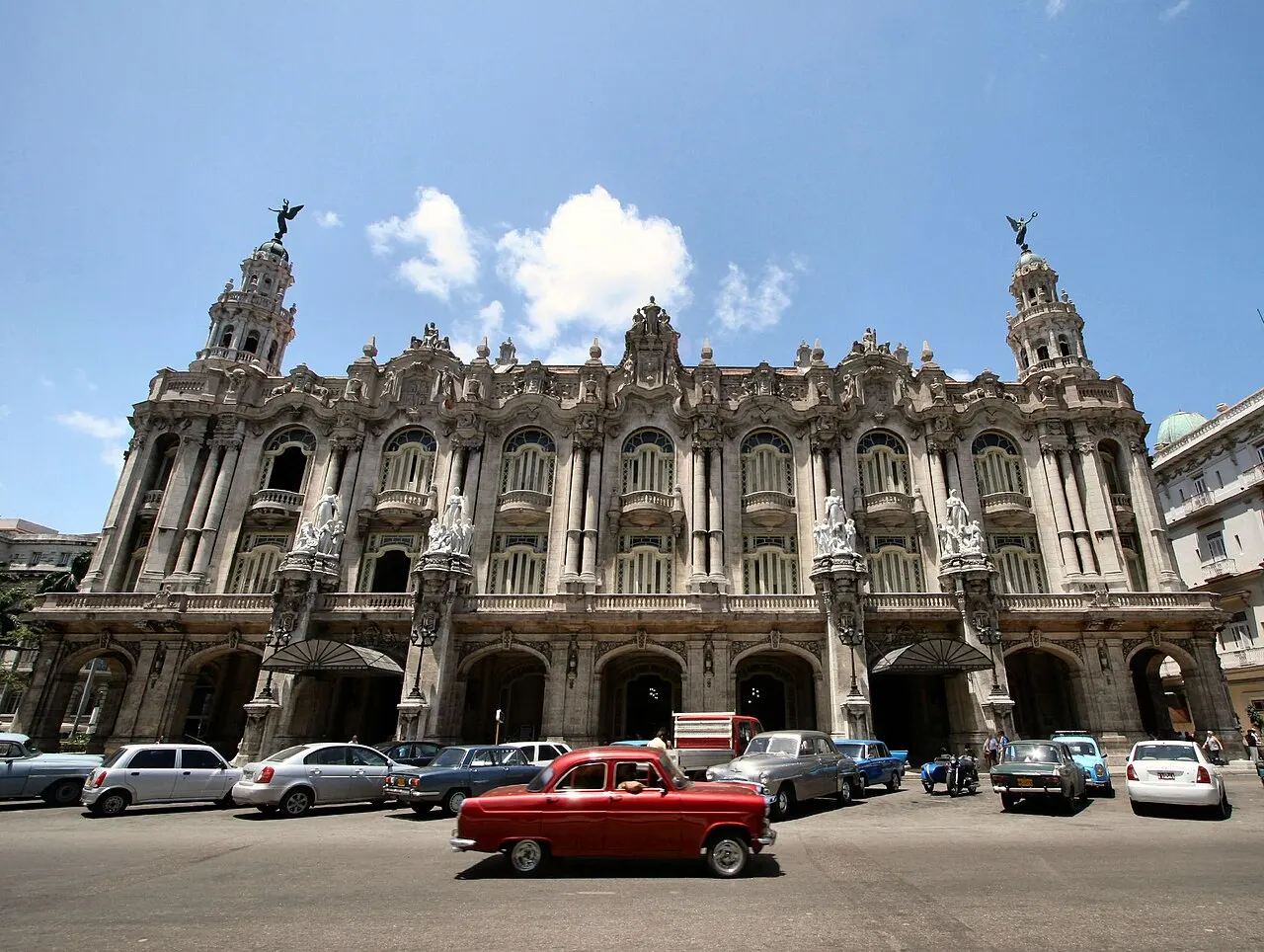 Fachada do Gran Teatro de La Habana, com torres, esculturas e sacadas, sob céu azul.