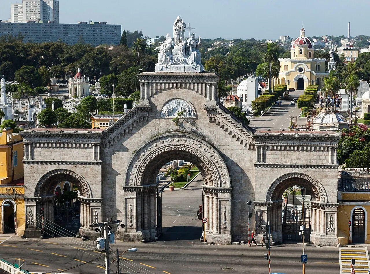 Portão monumental de pedra da entrada da Necrópolis de Cristóbal Colón, em Havana, com escultura no alto.