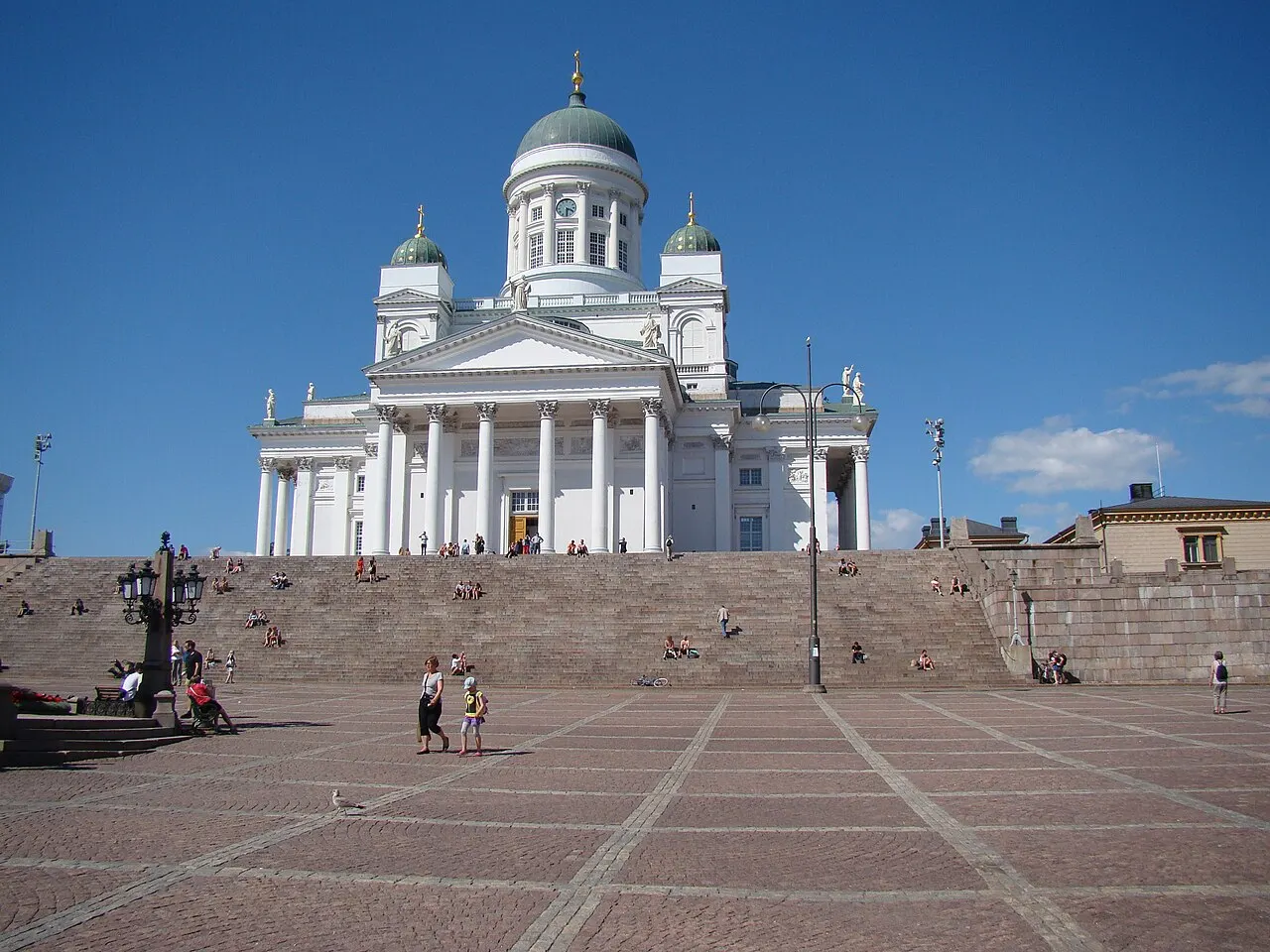 Catedral Luterana de Helsinque, branca com cúpulas verdes, no alto da escadaria da Praça do Senado.