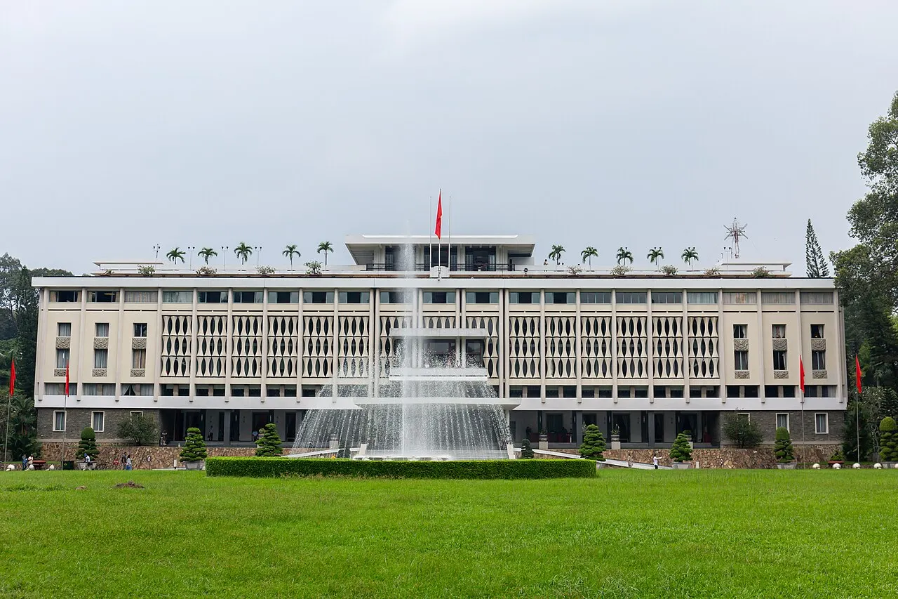O Palácio da Independência, prédio modernista branco de fachada simétrica com brises verticais e uma fonte em frente.