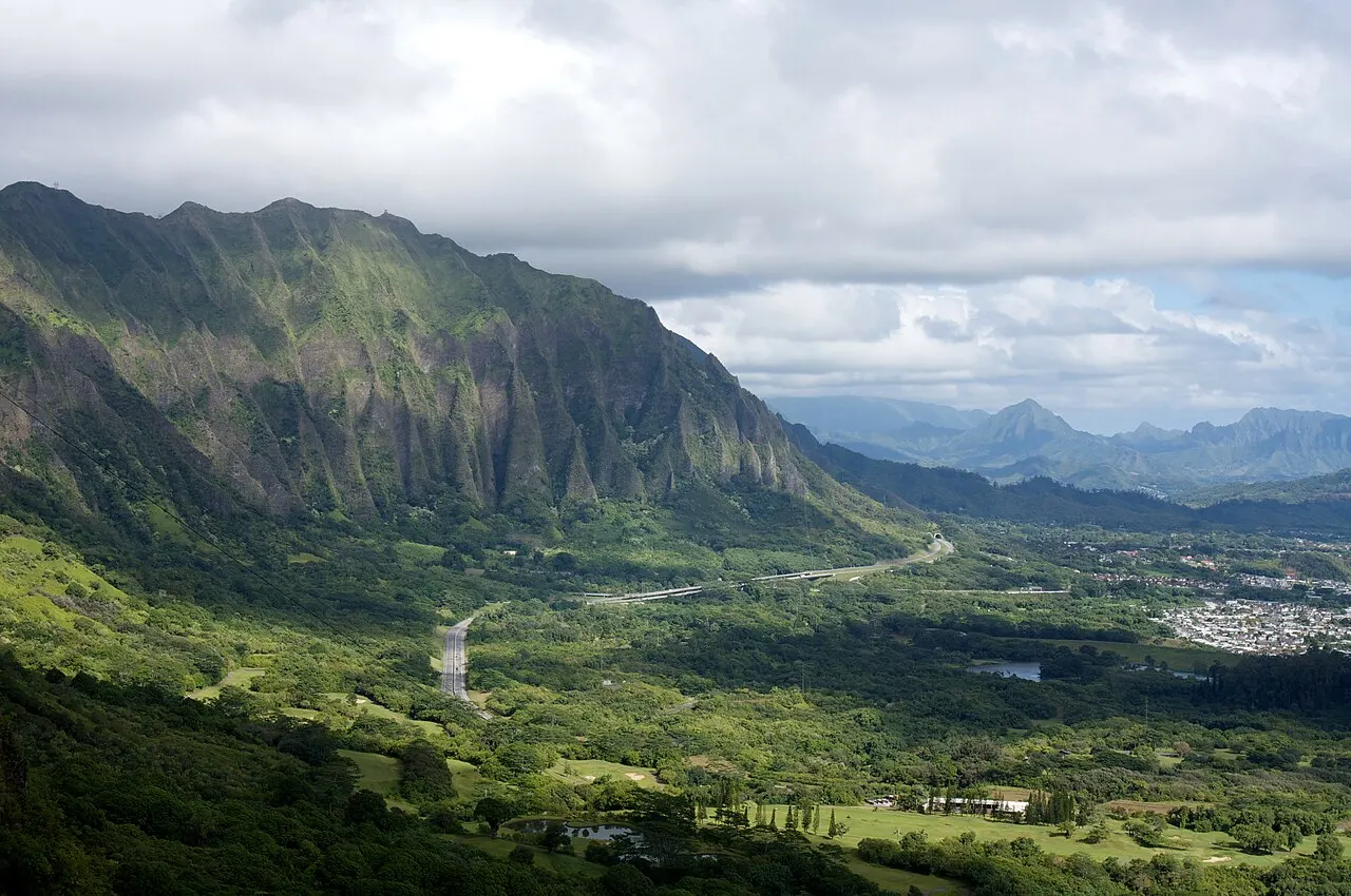 Os paredões verdes e sulcados da cordilheira Koʻolau vistos do mirante de Nuʻuanu Pali, com o vale e a costa de barlavento abaixo.