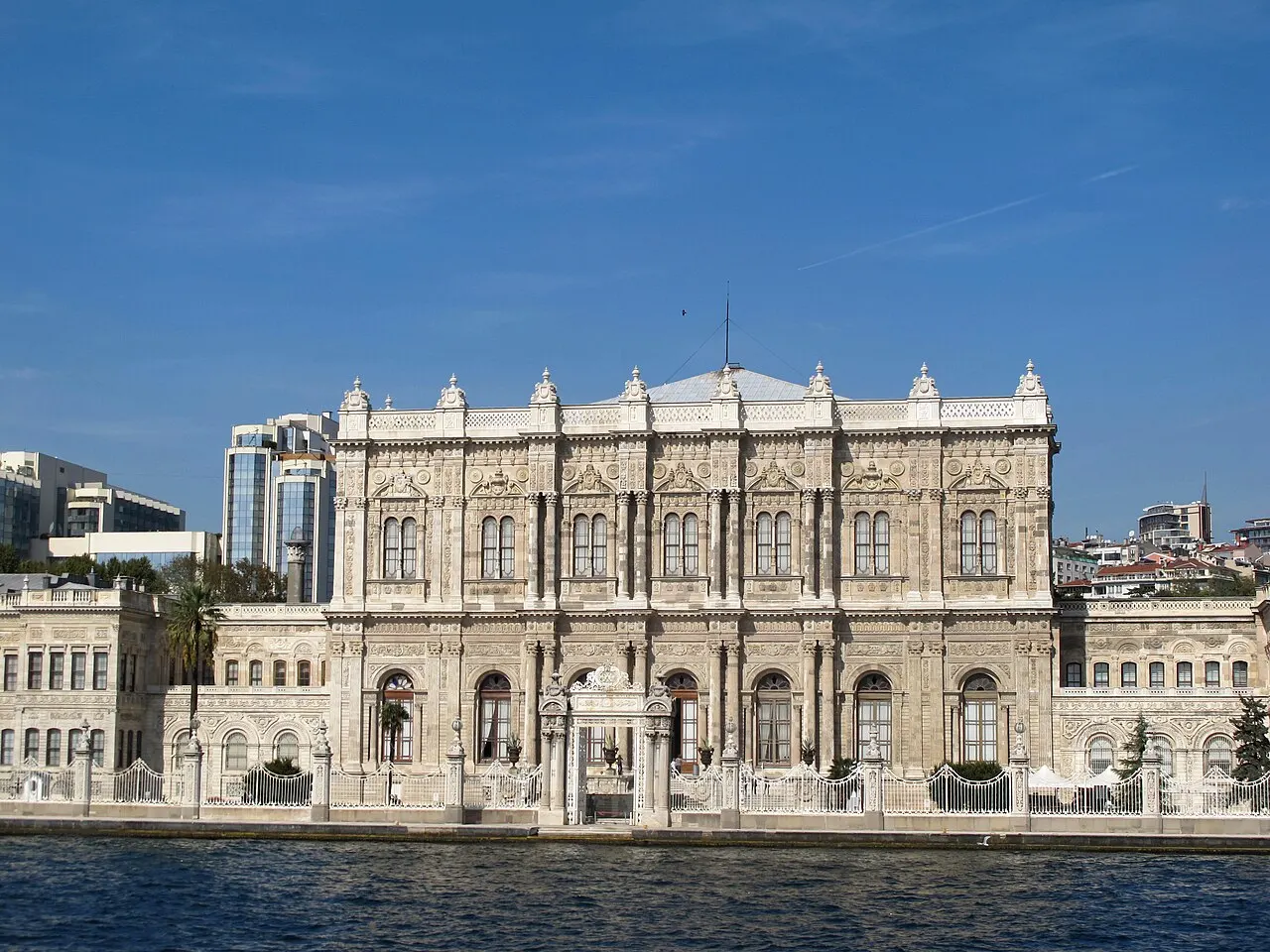 Fachada do Palácio de Dolmabahçe vista da água, com o portão central e a ala mais baixa à esquerda.