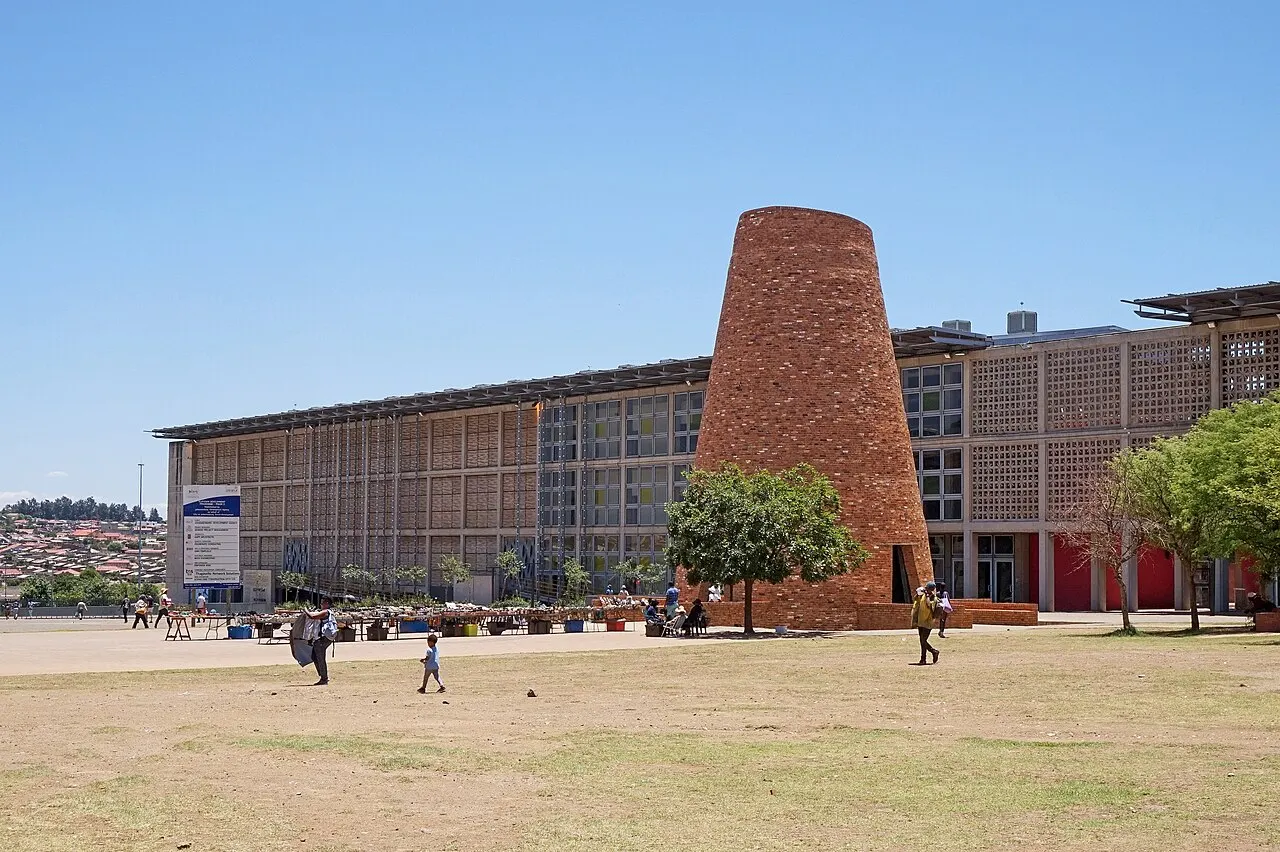 Monumento cônico de tijolo na Walter Sisulu Square, em Kliptown, Soweto, ao lado do prédio comprido da praça.