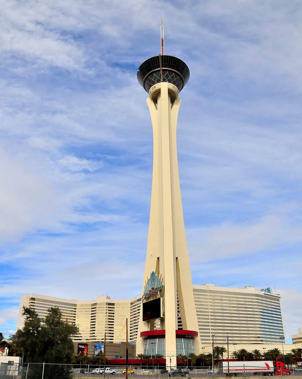 Torre do The STRAT, em Las Vegas, fina e alta, com a plataforma e a antena no topo, sob céu azul.