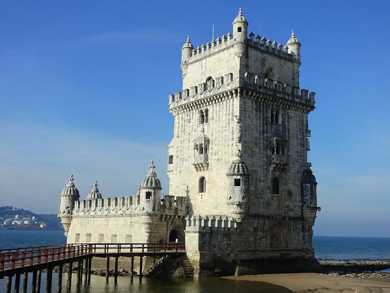 Torre de Belém, em Lisboa, com o baluarte e a torre de pedra rendilhada, à beira do Tejo.