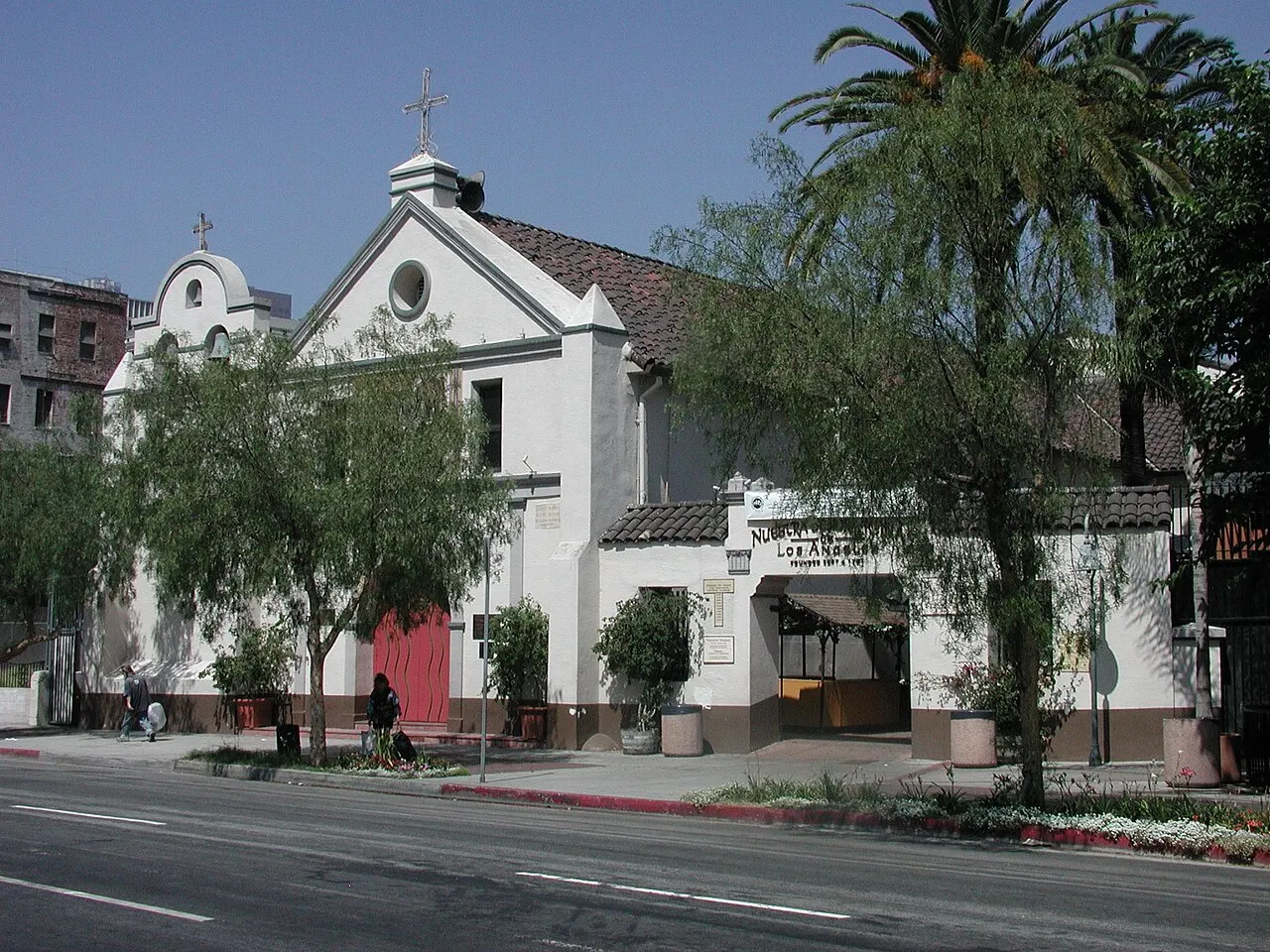 Igreja de La Placita, caiada, com campanário e cruz, na praça histórica de El Pueblo, em Los Angeles.