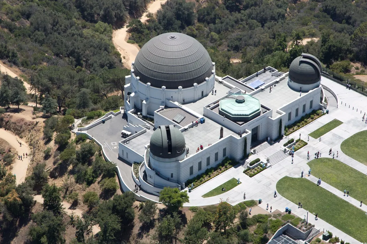 Observatório Griffith, em Los Angeles, prédio branco com três cúpulas, na encosta do parque.