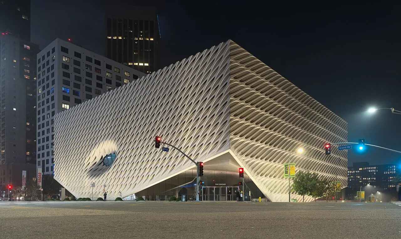 Museu The Broad, em Los Angeles, com a fachada branca de favos, iluminado à noite na esquina.