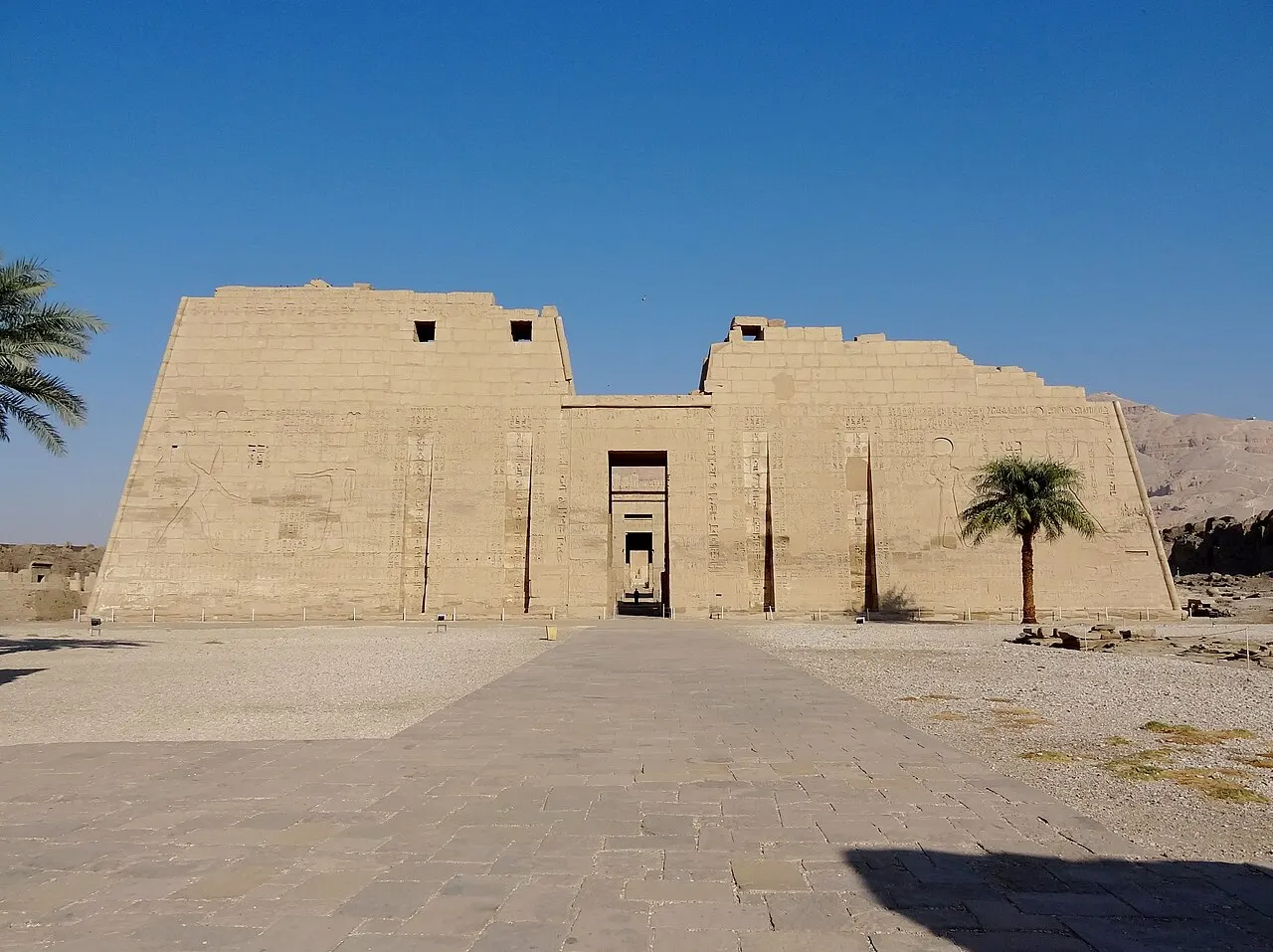 Primeiro pilone do templo funerário de Ramsés III, em Medinet Habu, com palmeiras ao lado.