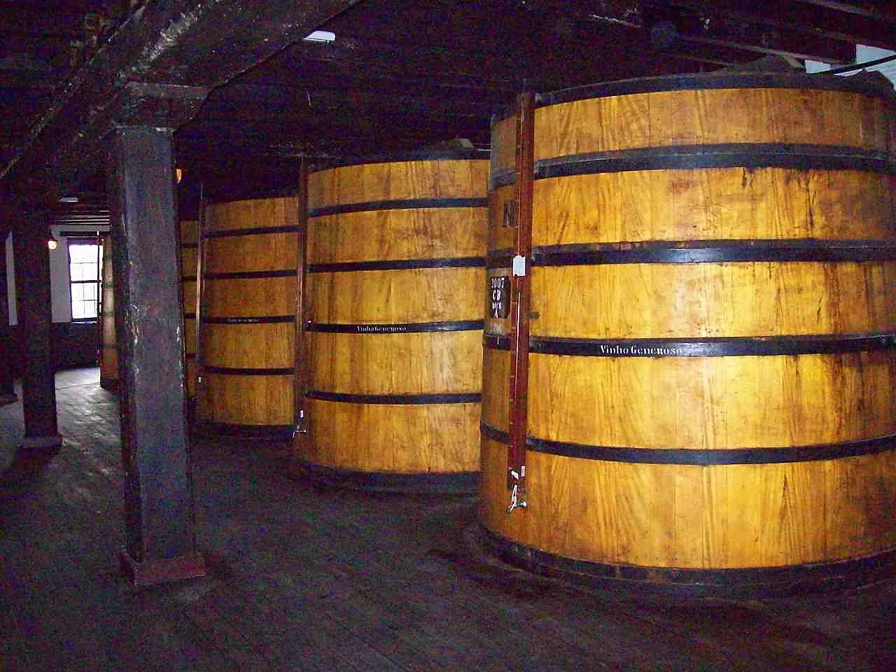Uma sala de teto de madeira na adega Blandy's, no Funchal, com grandes tonéis de vinho Madeira em fila.
