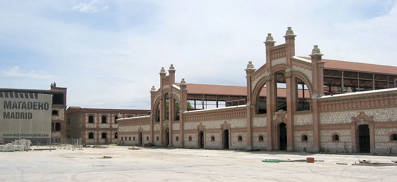 Naves de tijolo do Matadero Madrid, com o arco central e o letreiro do nome à esquerda.