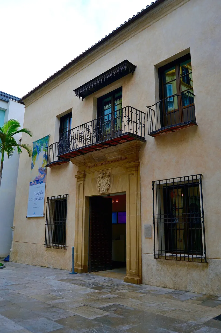 La façade claire du palais de Villalón, avec son portail de pierre, un balcon de fer et des fenêtres grillagées.