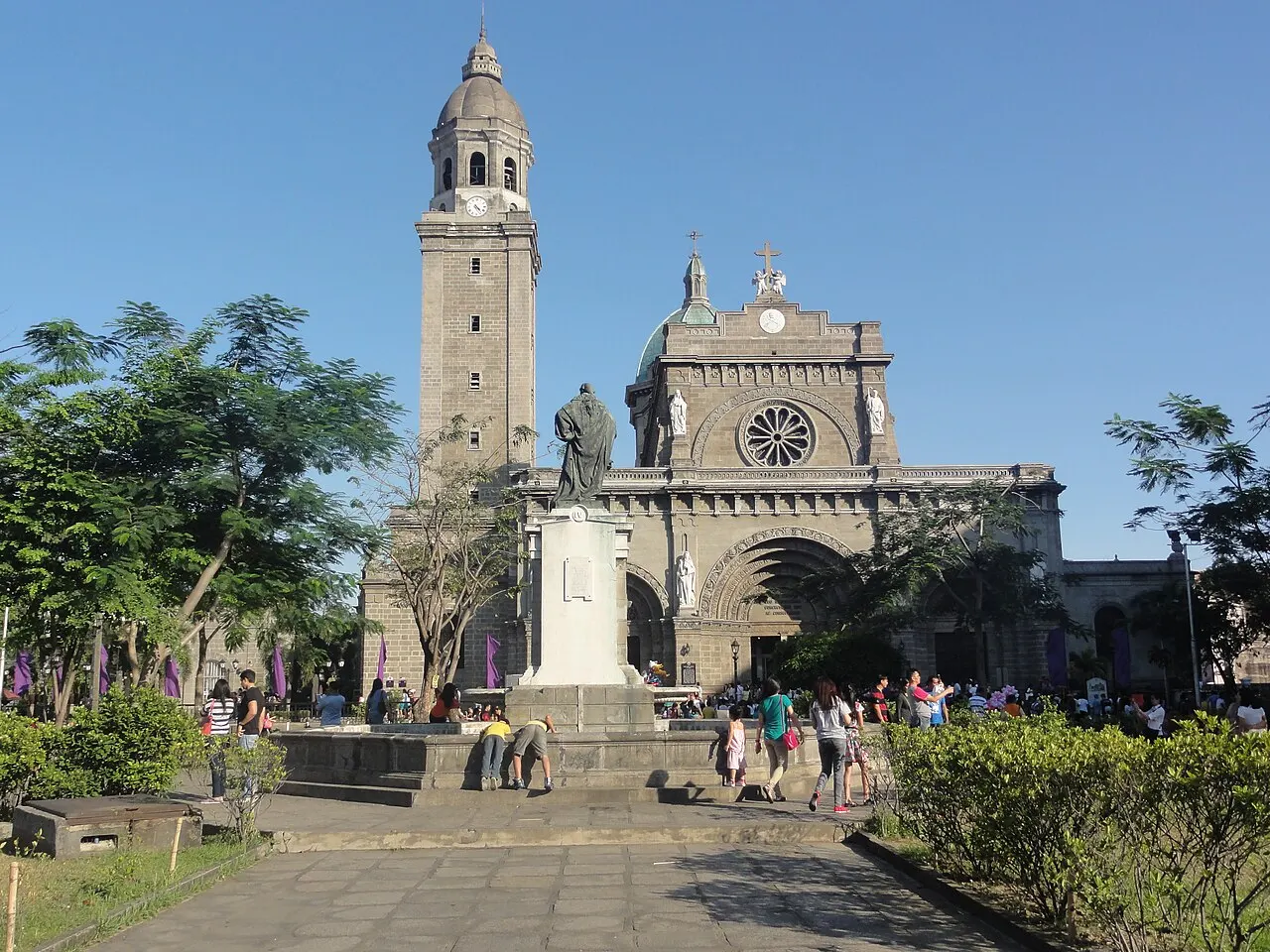 Fachada branca de catedral com uma rosácea central e um campanário octogonal separado.