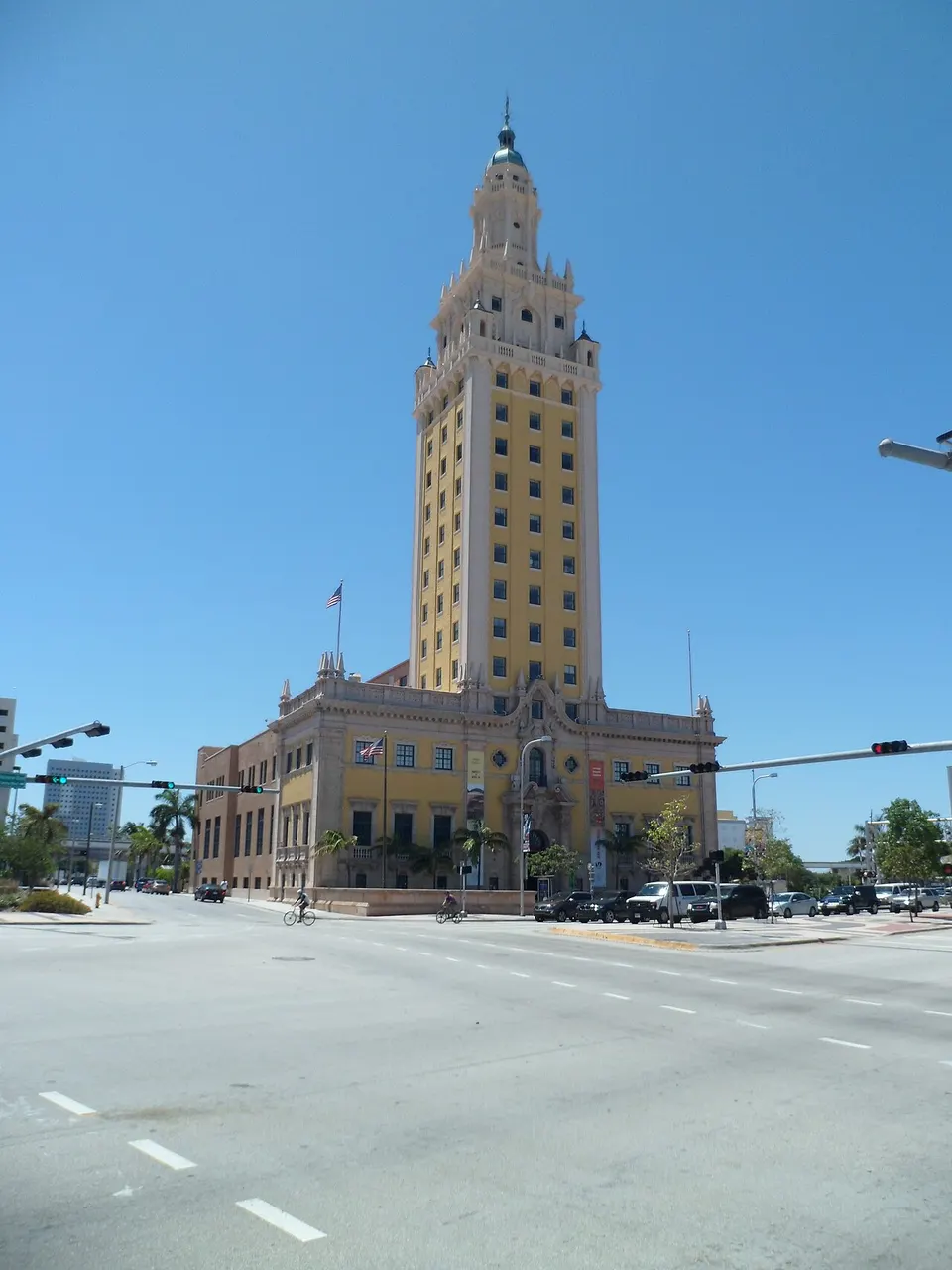 Freedom Tower, em Miami, torre clara de estilo espanhol com lanterna no alto, sob céu azul.