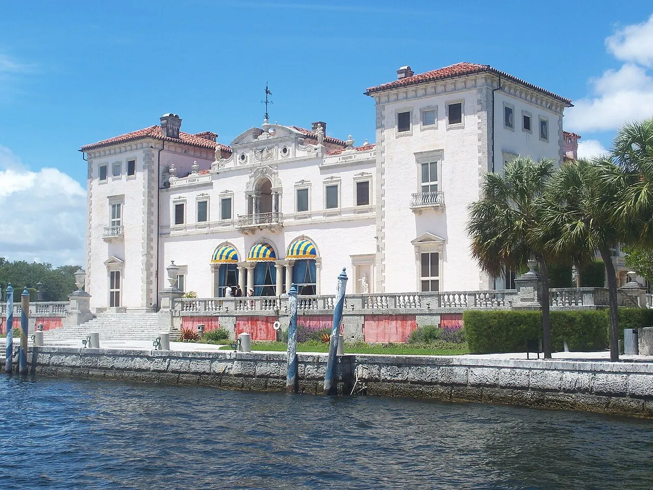 Casa principal do Vizcaya Museum and Gardens, em Miami, branca com telhado de telhas, à beira da baía.