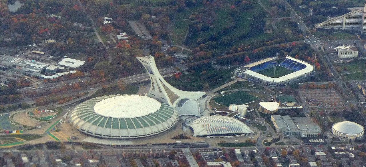 Vista aérea do Parque Olímpico de Montreal, com o estádio, a torre inclinada e o antigo velódromo, hoje Biodôme.