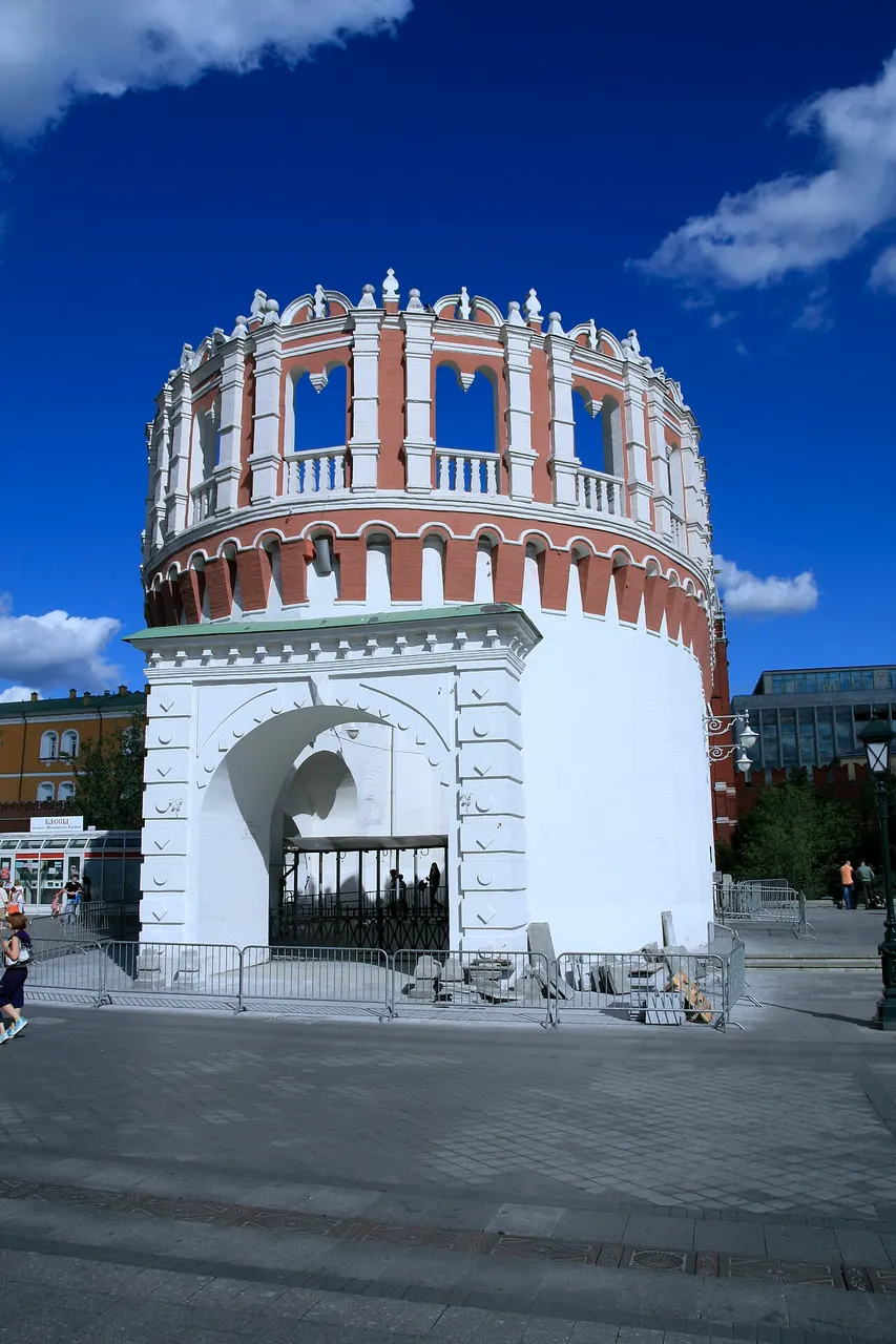 Torre Kutafia, na entrada do Kremlin de Moscou, de tijolo branco e vermelho sob céu azul.